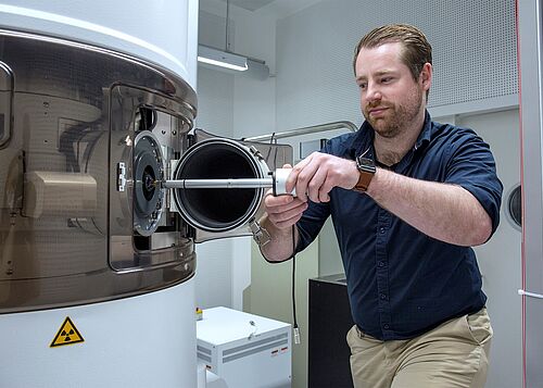 Der wissenschaftliche Koordinator von ELMI-MV, Dr. Kevin Oldenburg, bringt eine neue Probe zur wissenschaftlichen Untersuchung in das neue Elektronenmikroskop ein (Foto: Julia Tetzke/Universität Rostock).