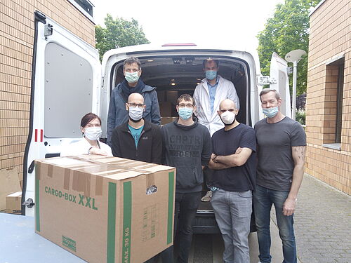 Erste Reihe: Jana Unger, Frank Janert, Maximilian Quasdorf, Rúben Manuel Figueira de Abreu, Ricardo Molenda. Zweite Reihe: Prof. Peter Langer, Dr. Peter Ehlers (alle v.l.) beim Beladen des LKW. (Foto: Universität Rostock/Institut für Chemie).