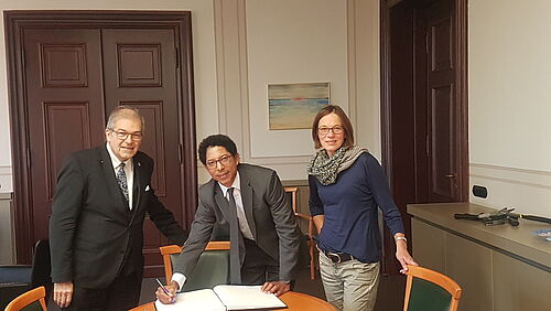 Professor Roldán Torres von der Ikiam Universität trägt sich in das Gästebuch der Universität Rostock ein. Zu seiner Linken Rektor Professor Dr. Wolfgang Schareck und zu seiner Rechten Professorin Bettina Eichler-Löbermann. (Foto: Michael Paulus, RIH)?).