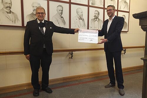 v.r.: Alexander Gatzka, Öllermann der Kaufmannschaft zu Rostock,übergibt den Scheck an Professor Wolfgang Schareck, Rektor der Universität Rostock, (Foto: Universität Rostock / Pressetelle).