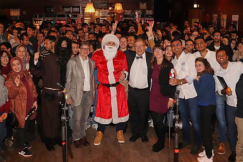 Die Prorektorin für Internationales, Gleichstellung und Vielfaltsmanagement der Universität Rostock, Professorin Maike Klettke, Rektor Professor Wolfgang Schareck und zur rechten des Weihnachtsmannes Michael Paulus, Leiter des Rostock International House, umringt von internationalen Studierenden der Universität Rostock 